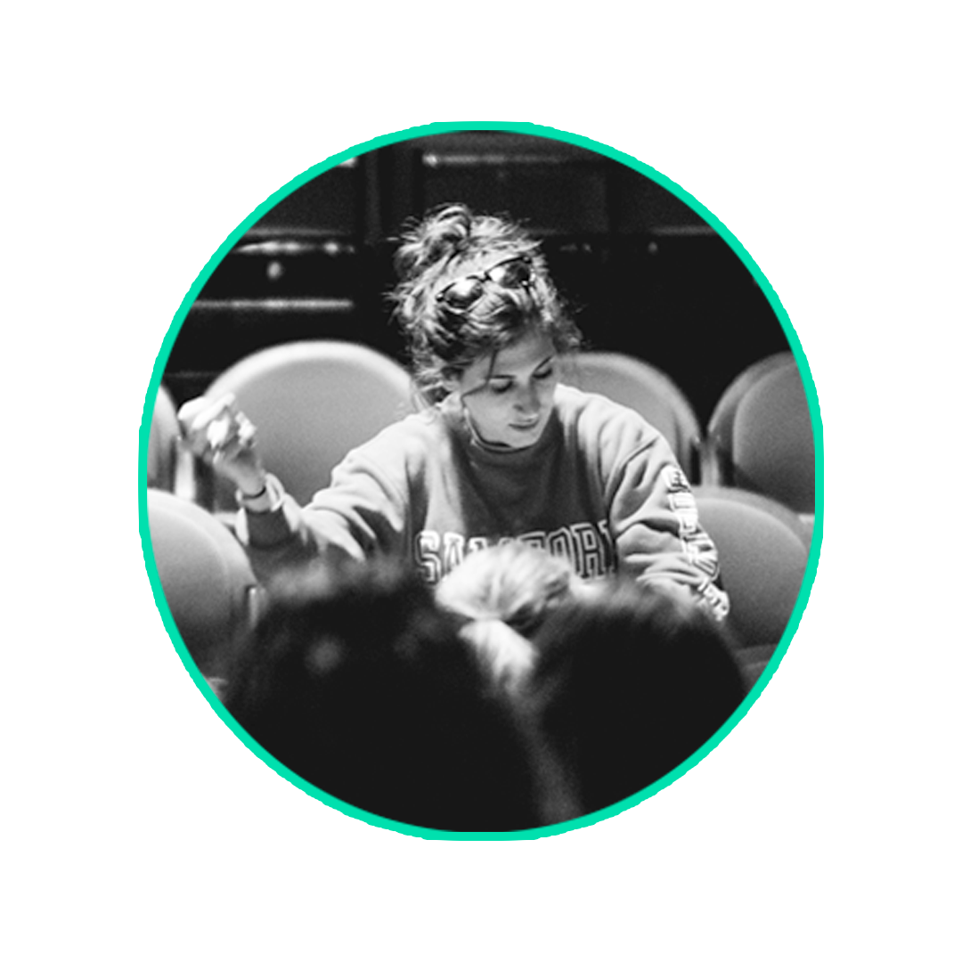 Music educator working with students in a theater setting
